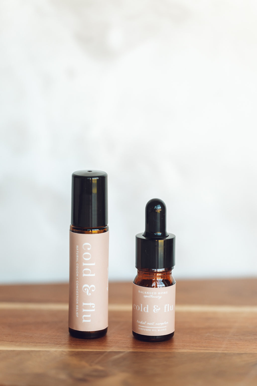 Two skincare products on a wooden surface with a white background