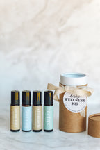 Baby wellness kit with roller bottles and a cardboard container on a light background